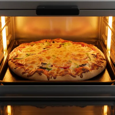 A small personal pizza baking inside a Panasonic FlashXpress Toaster Oven, with the interior light on, showing perfectly melted cheese and a crispy crust.